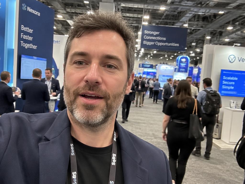 Fictional machinery company founder filming a selfie video on the trade show floor